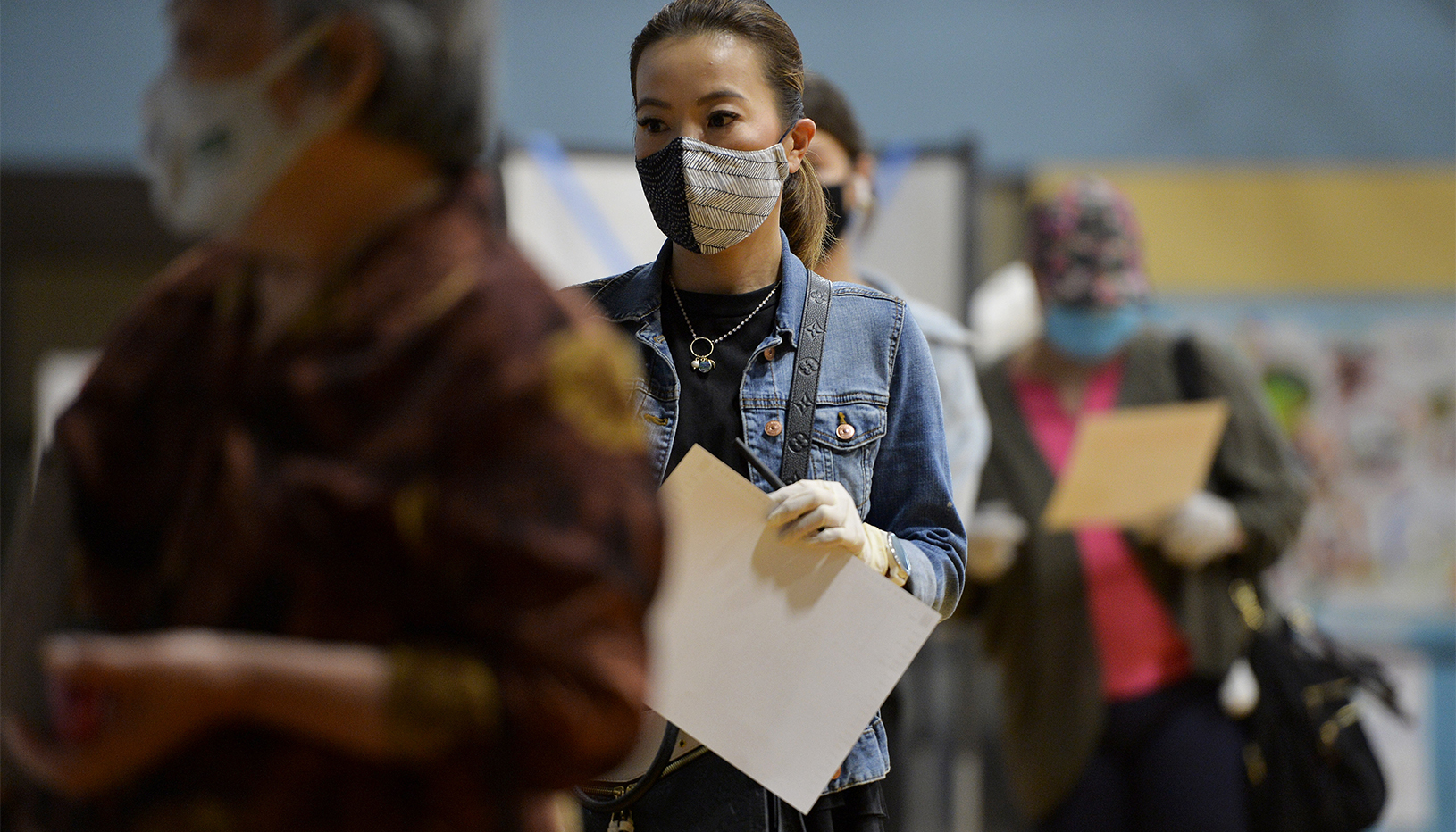 Woman in face-mask in line to vote