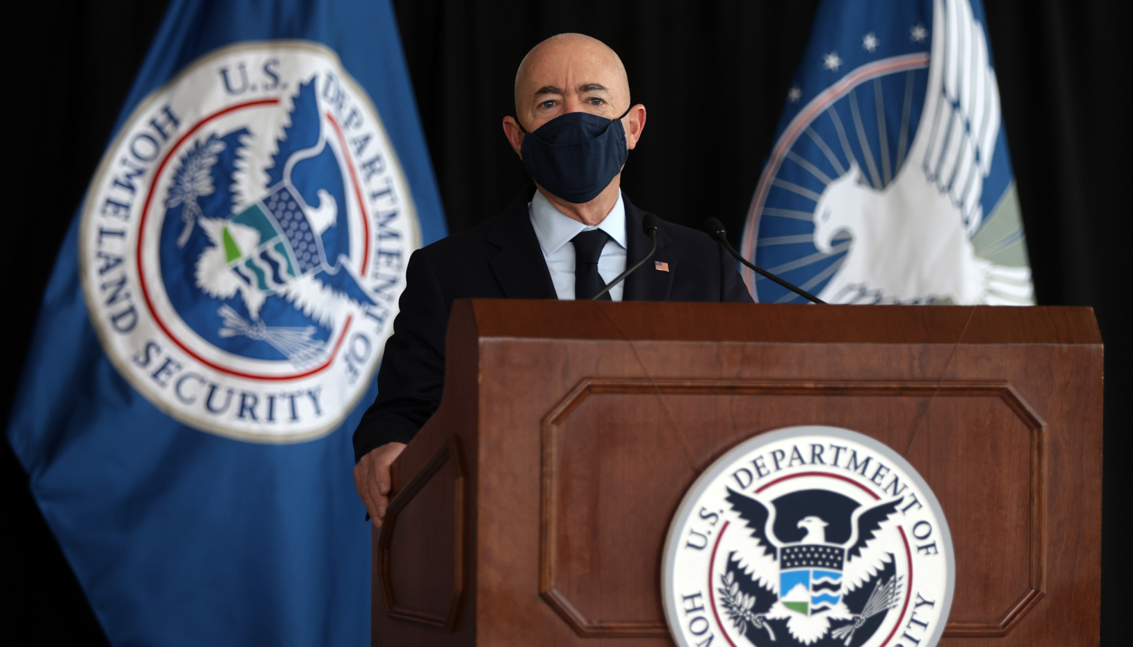 Secretary Alejandro Mayorkas speaking behind a podium