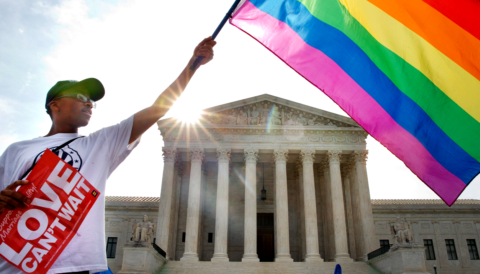 Person waving pride flag in front of Supreme Court
