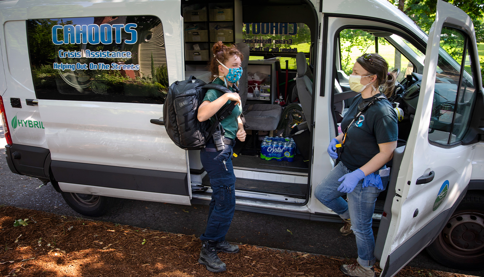 CAHOOTS first responders from Eugene, Oregon, talk outside their van.