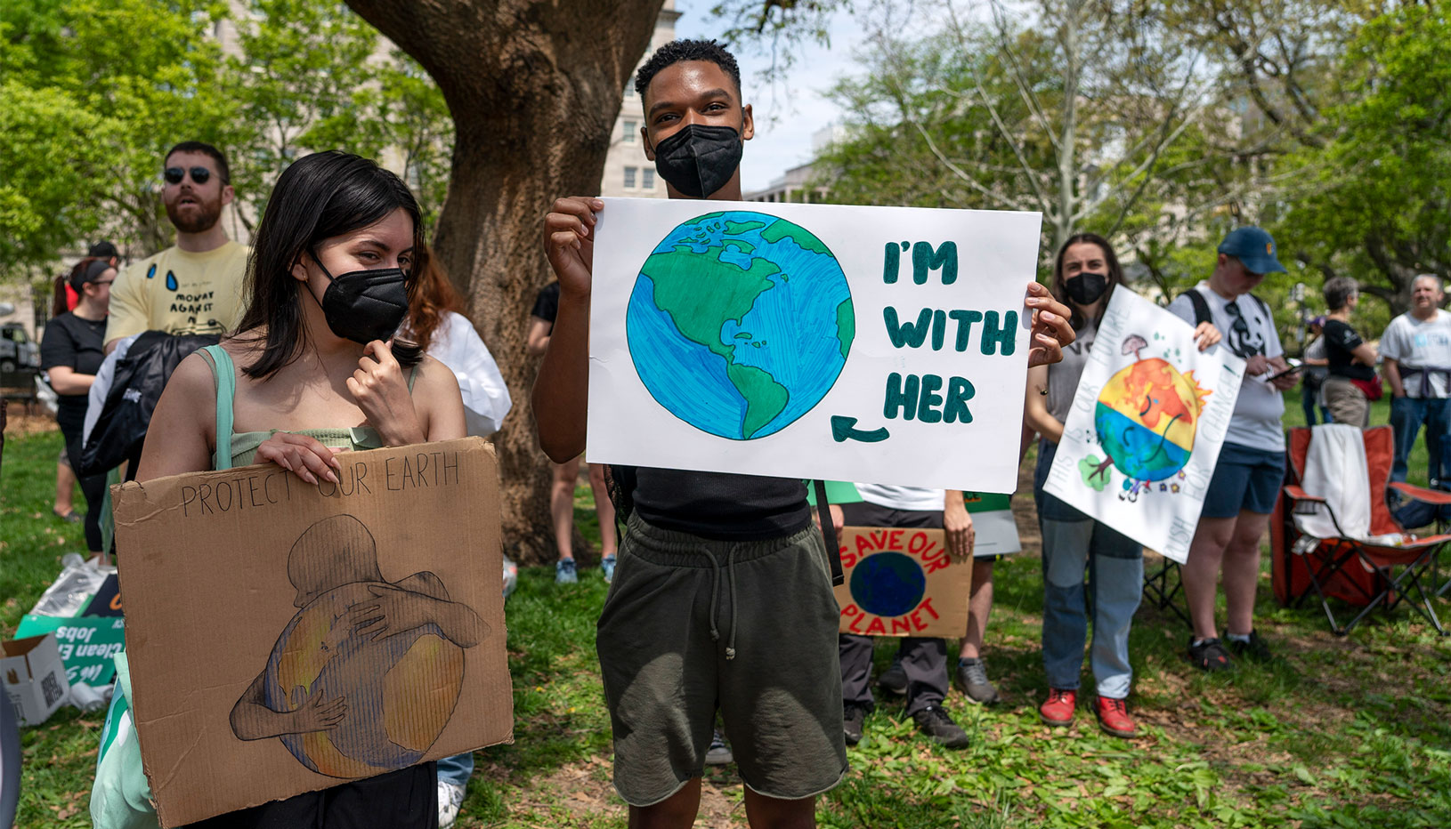 Young environmental activists holding signs
