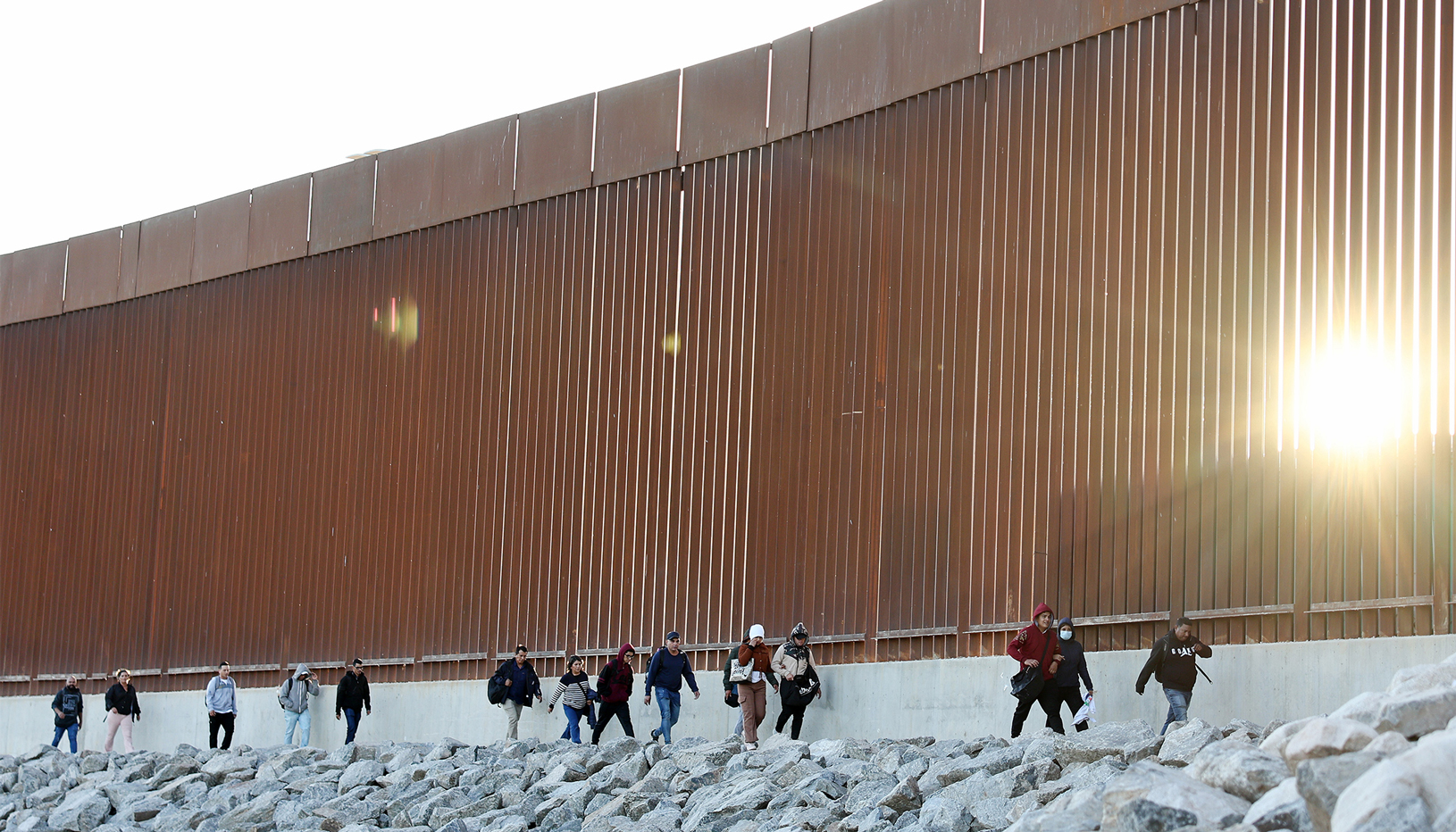 People walking at the US-Mexico border wall