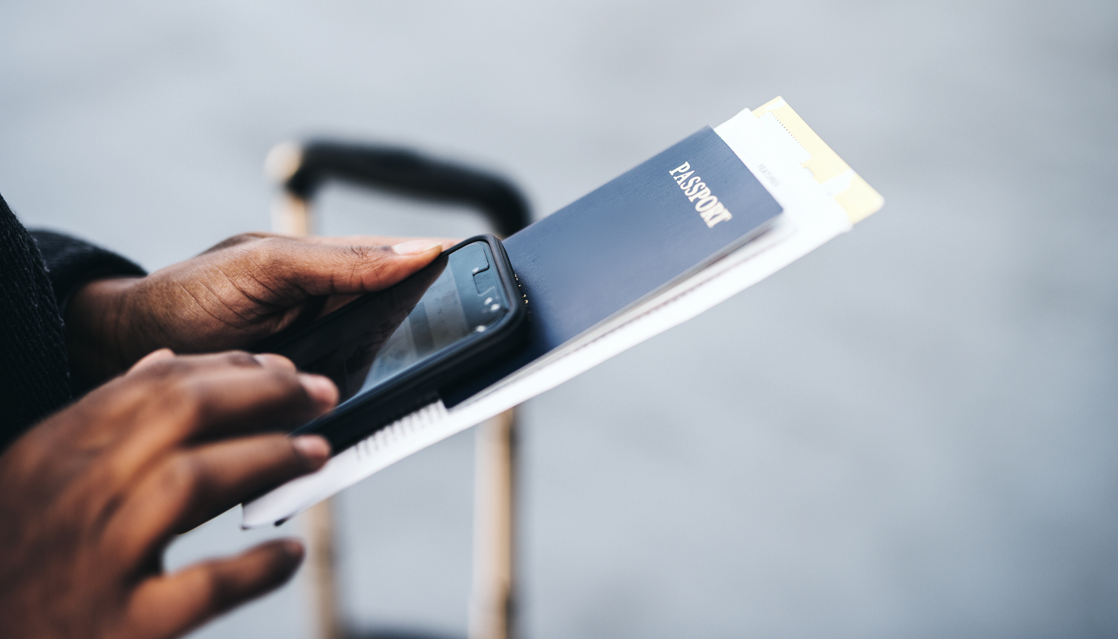 Man at airport holding passport and phone