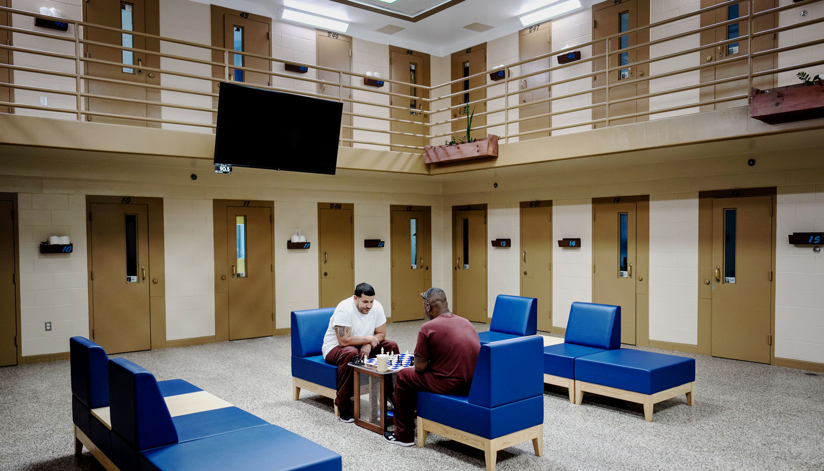 two incarcerated individuals playing chess in prison