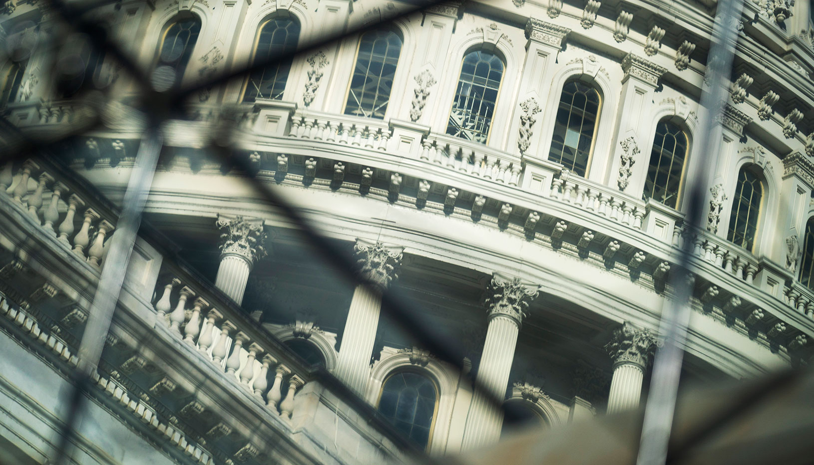 Photo of a government building through links in a fence.