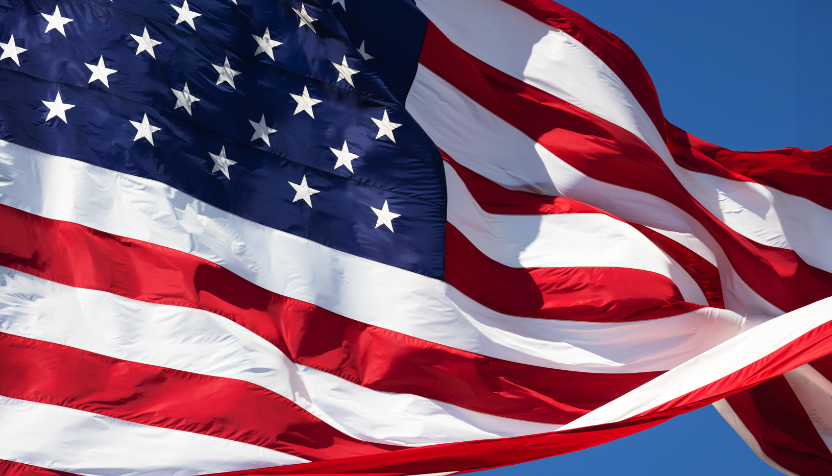 waving American flag against blue sky