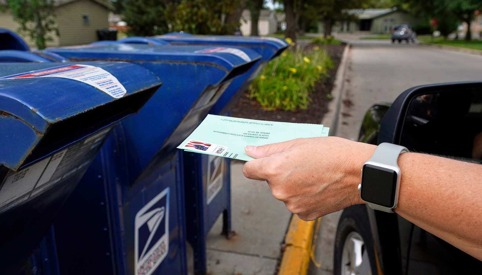 Mail ballot being dropped in mail slot