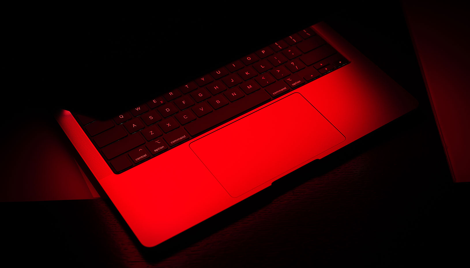 Laptop halfway open showing red light
