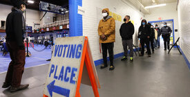 Voters line up in a hallway at their polling place