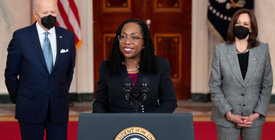 Judge Ketanji Brown Jackson speaks at the presidential podium flanked by President Biden and Vice President Harris