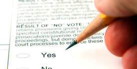 Hand holding a pencil over a ballot question