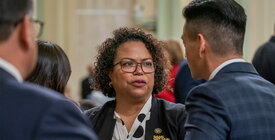 California Assemblymember Mia Bonta talking to other assemblymembers