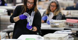 Person counting election ballots