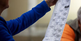 Election officials checks a voter's ballot.