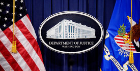 DOJ signage between two flags