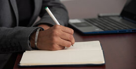 Foto de una mano con la escritura de bolígrafo en un cuaderno