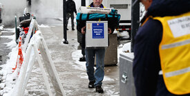 Election worker carrying ballots outside in snow