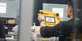 worker holding up yellow bag with Fulton County elections written on it