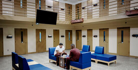 two incarcerated individuals playing chess in prison