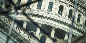 Photo of a government building through links in a fence.