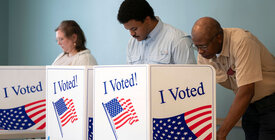 Three people voting at booths with I Voted imagery