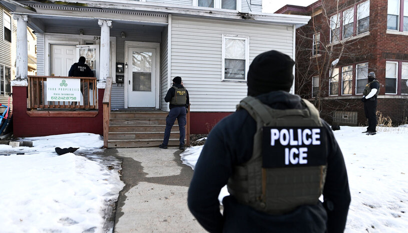 Photo of four ICE agents outside a residential building