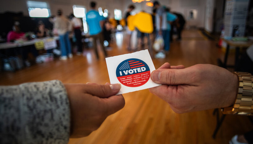 People holding an "I voted" sticker