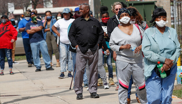 Residents wait in long line to vote in a presidential primary election outside the Riverside High School in Milwaukee, Wisconsin, on April 7, 2020