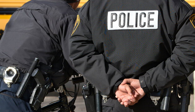 Police officer with hands behind back