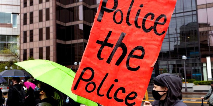 Protester holds sign, "Police the police."