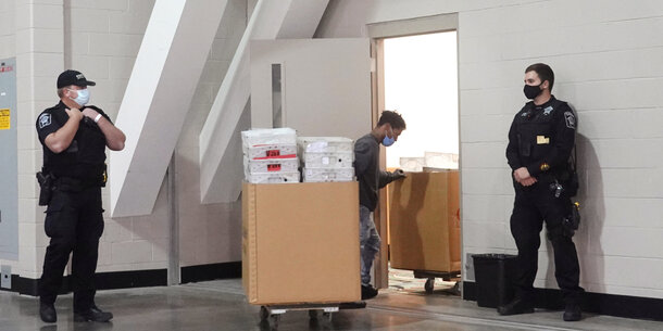 Police stand guard outside of a room in the Wisconsin Center where ballots are being stored