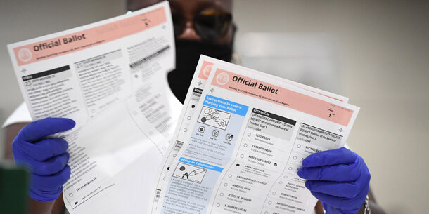 An election worker revises a ballot