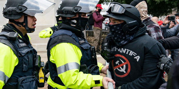 A participant in the January 6th riot confronts police