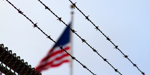 The U.S. flag behind barbed wire