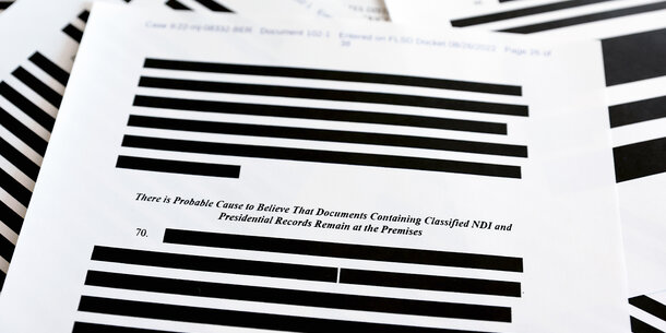 Classified documents with portions redacted
