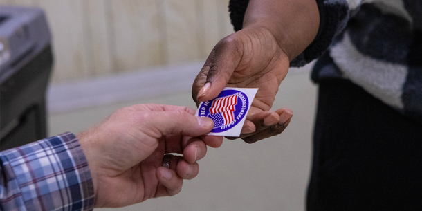 two hands holding a voting sticker