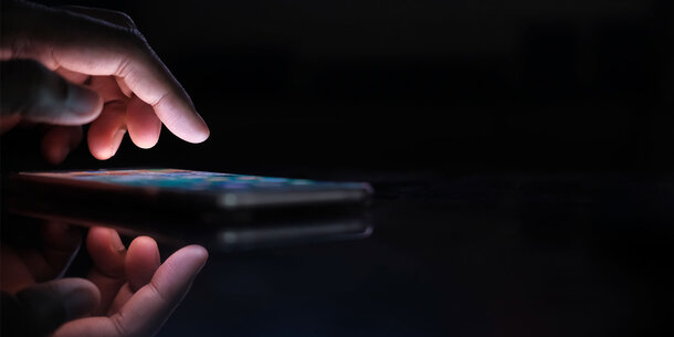 Person holding smartphone in the dark