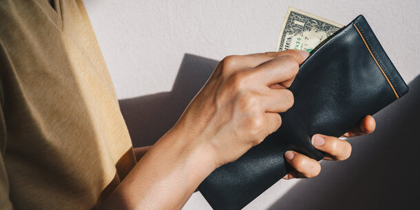 Person holding $1 bill