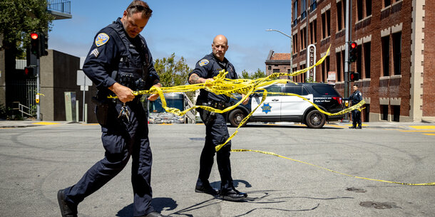 Police officers handling crime scene tape