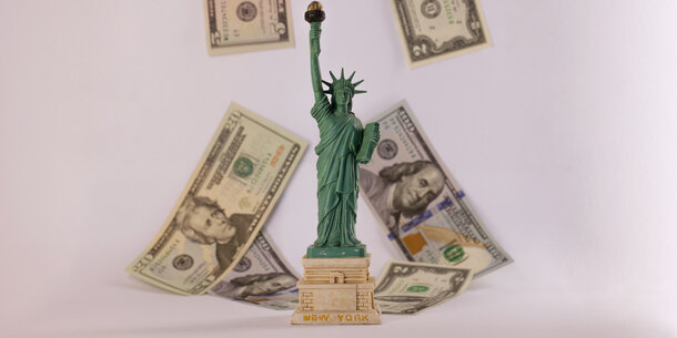 Model Statute of Liberty foreground, cash in background