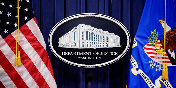 DOJ signage between two flags