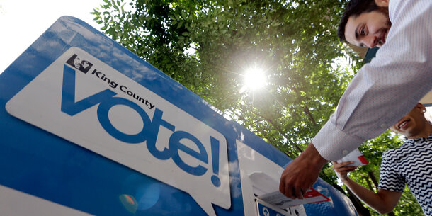 Voter delivering ballot to King County ballot drop box
