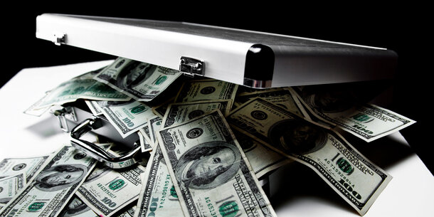 Cash spilling from silver briefcase