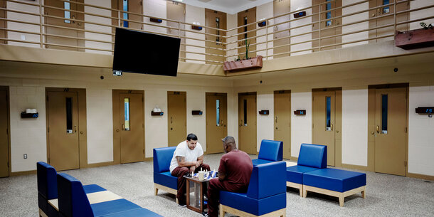two incarcerated individuals playing chess in prison