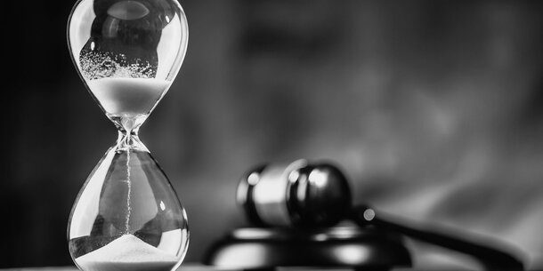 black and white image of hourglass and gavel