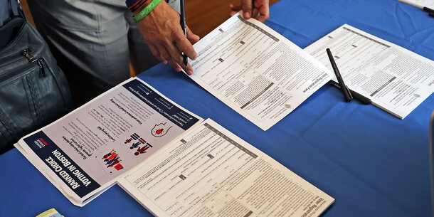voter registration forms on table with blue tablecloth