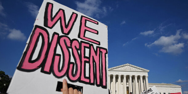 "We Dissent" poster in front of U.S. Supreme Court