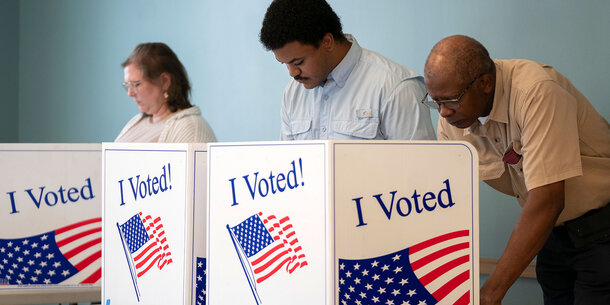 Three people voting at booths with I Voted imagery