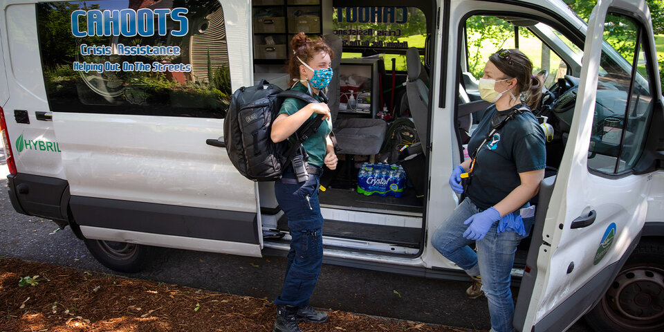 CAHOOTS first responders from Eugene, Oregon, talk outside their van.