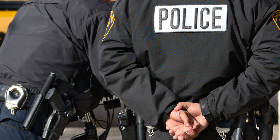 Police officer with hands behind back